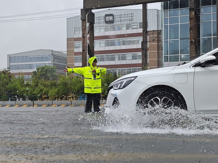 人工推车、警车护送！风雨中的上海街头，执勤民警满岗运行